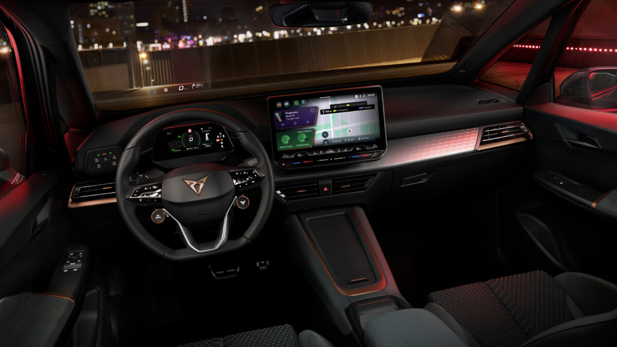Der Innenraum des Cupra Born VZ mit Blick auf das zentrale 12-Zoll-Display und das Sportlenkrad mit VZ-Logo. Das Cockpit kombiniert digitale Anzeigen mit physischen Bedienelementen und verfügt über Sportschalensitze mit Alcantara-Bezug in der VZ-Ausstattung.