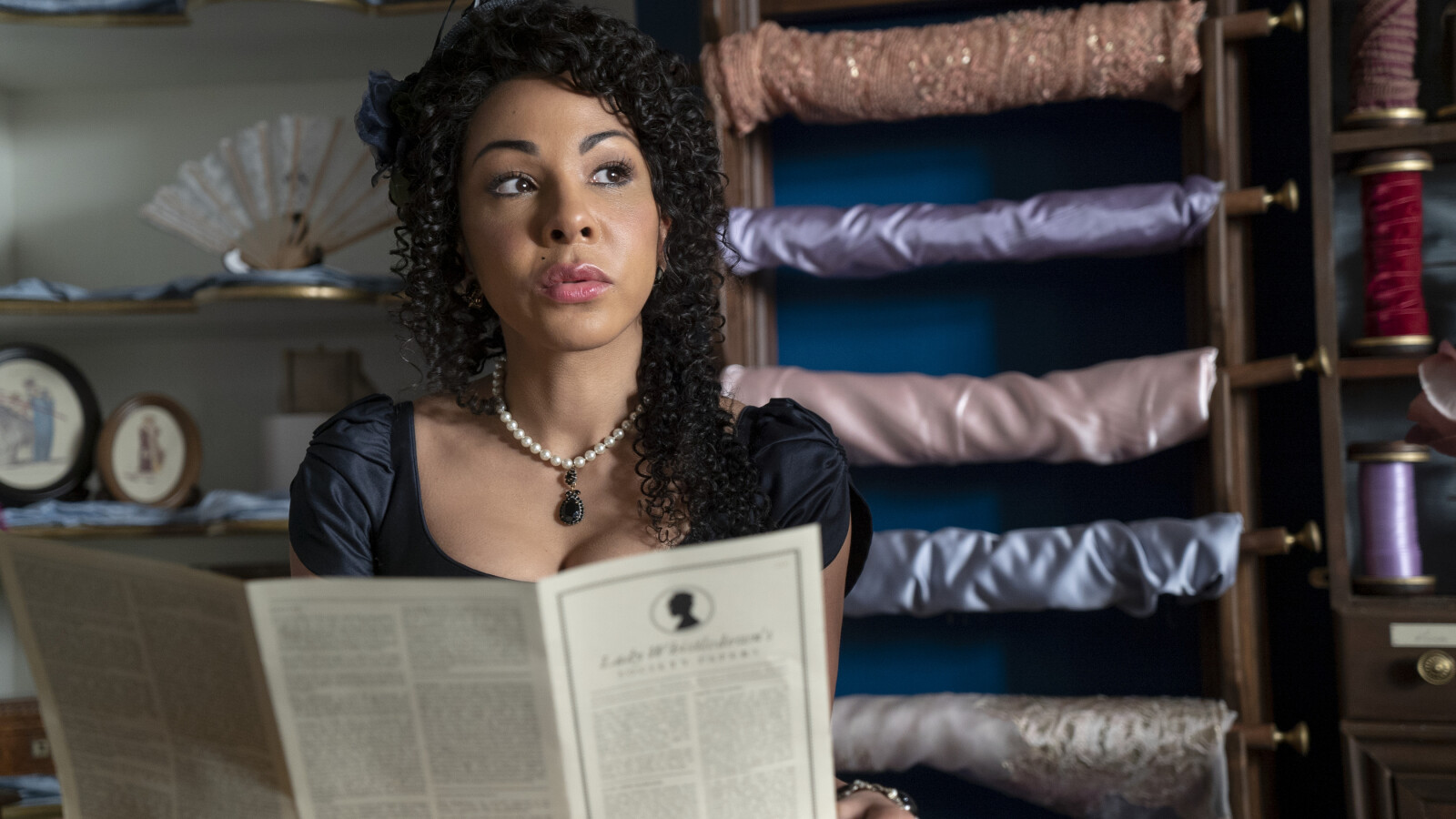 Bridgerton: Auch Genevieve Delacroix ist von Lady Whistledowns neuesten Enthüllungen fasziniert.