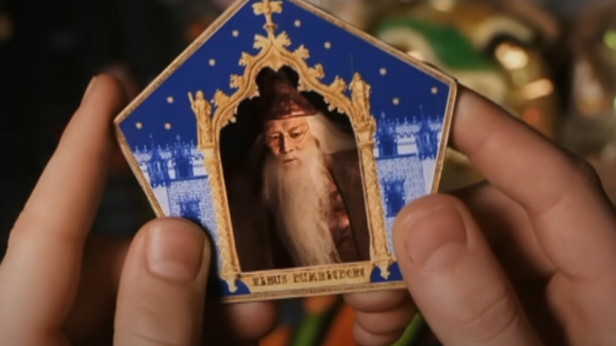 Harry Potter und der Stein der Weisen: Harry (Daniel Radcliffe) zieht die Schokofroschkarte von Albus Dumbledore (Richard Harris).