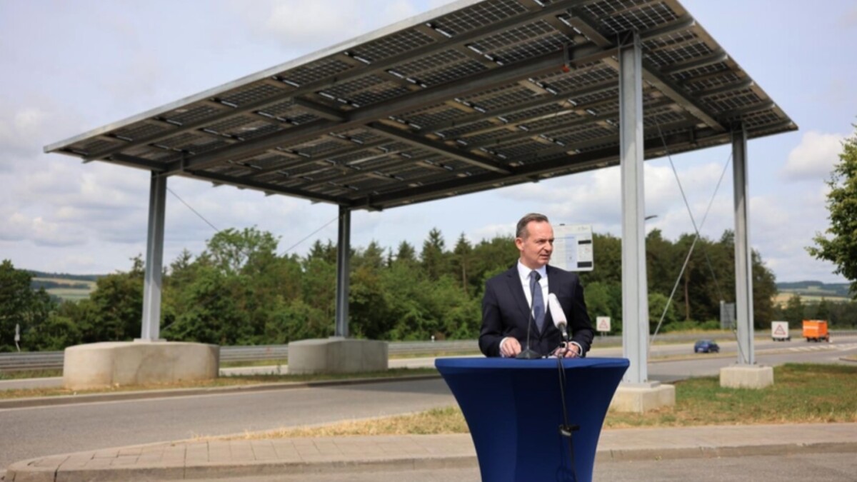 El ministro de Transporte Volker Wissing, al fondo el primer techo solar de autopista.