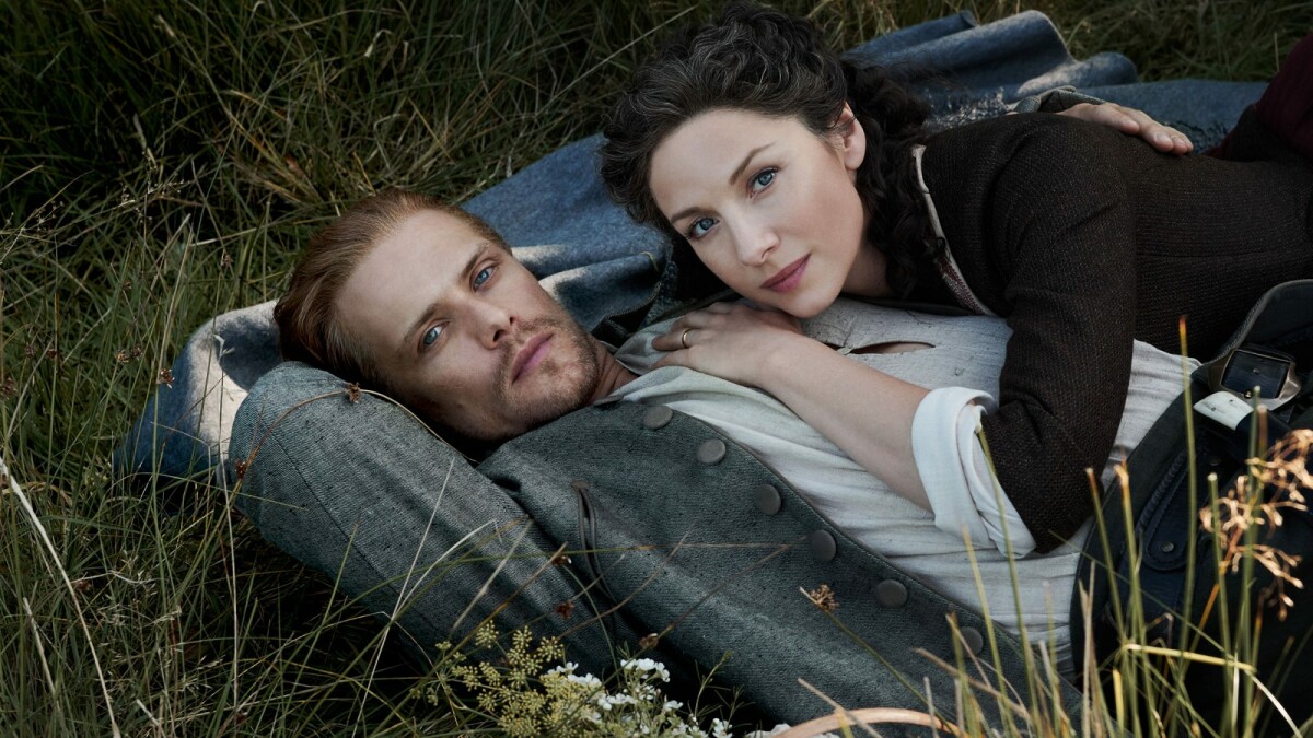 Outlander: Jamie (Sam Heughan) and Claire (Caitriona Balfe) are lying in a meadow.