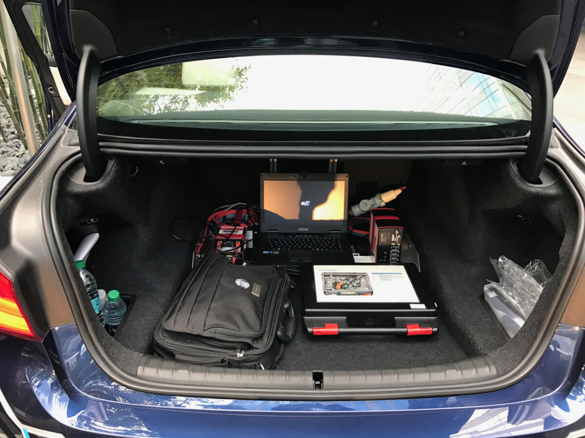 Der Kofferraum wirkt noch ein wenig chaotisch, schließlich handelt es sich um einen Prototyp. Der Laptop gleicht während der Fahrt permanent das Fahrzeug-GPS mit einer hochauflösenden Karte ab.