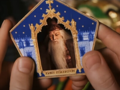 Harry Potter und der Stein der Weisen: Harry (Daniel Radcliffe) zieht die Schokofroschkarte von Albus Dumbledore (Richard Harris).