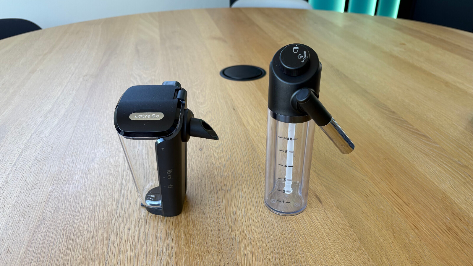 Links der dreiteilige "LatteGo"-Becher von Philips, rechts der "LatteCrema"-Behälter von DeLonghi mit beweglichem Ausgabestutzen.